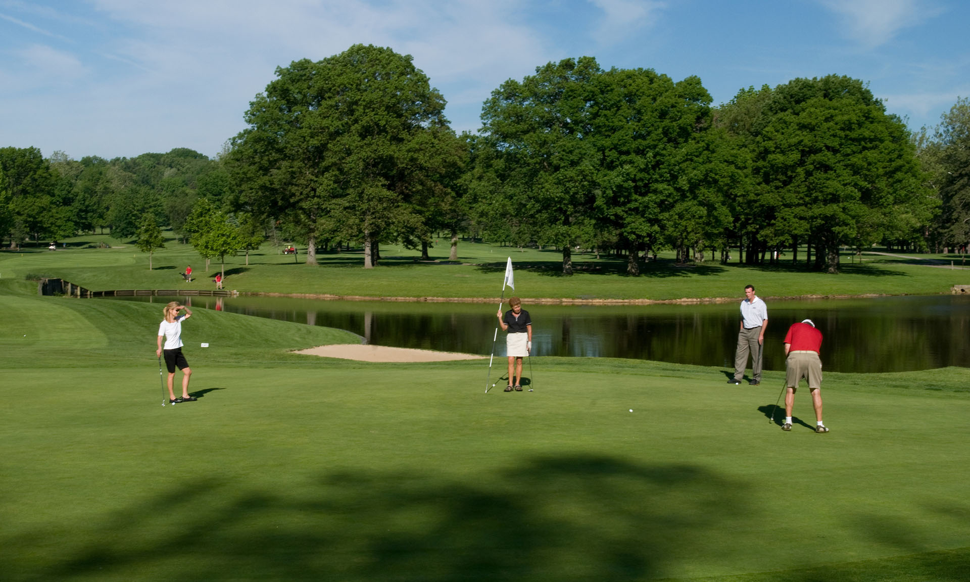 People golfing on a golf course