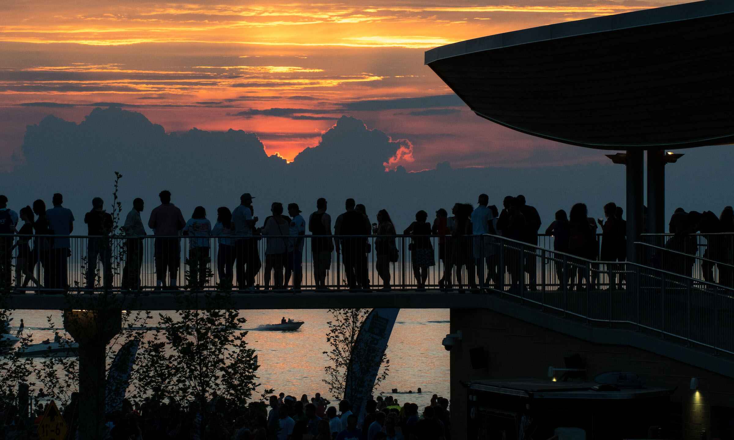 A diverse group of individuals standing together on a bridge, enjoying the view and each other's company.