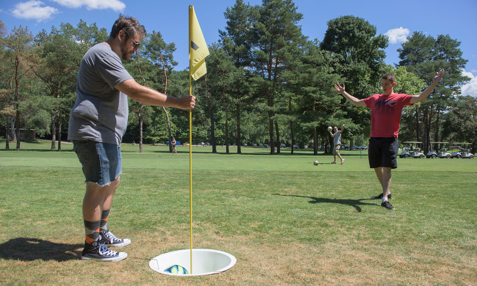 People celebrating at a foot golf hole