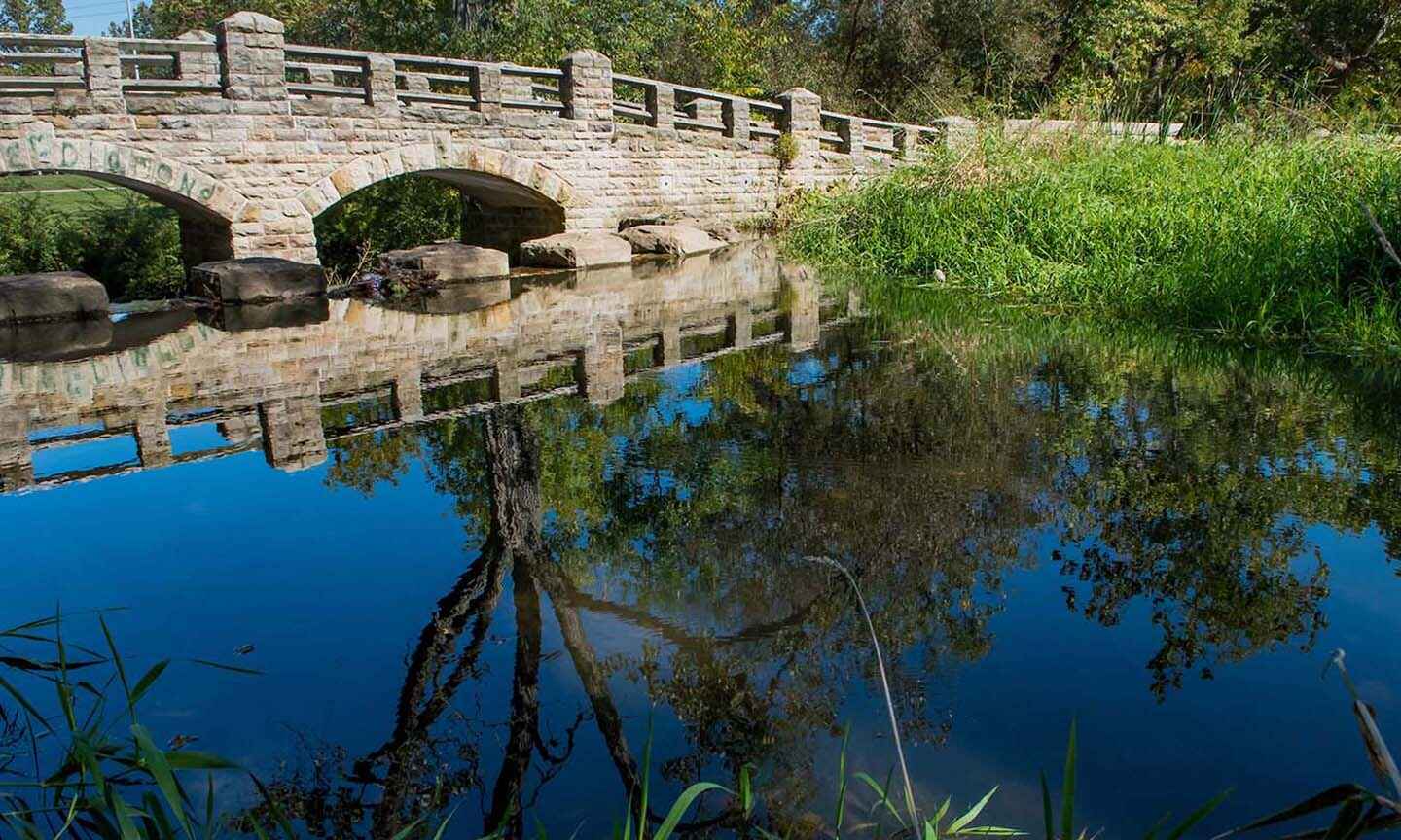 A stone bridge over a pond