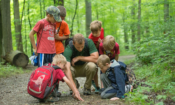 A group of kids and a counselor on a hike