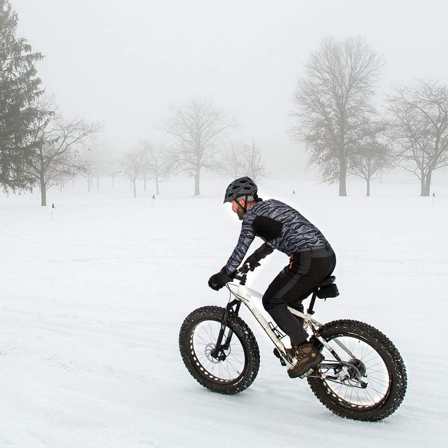 A man riding a bike in the snow