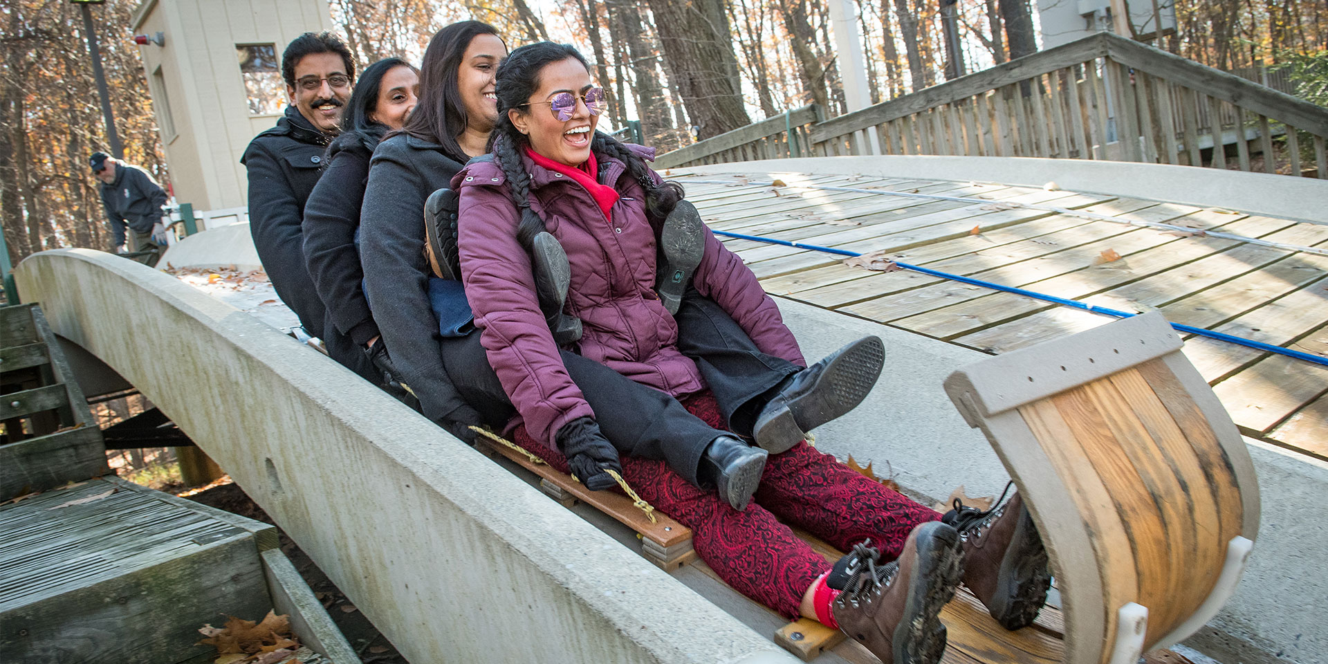 People smiling while ridding a toboggan