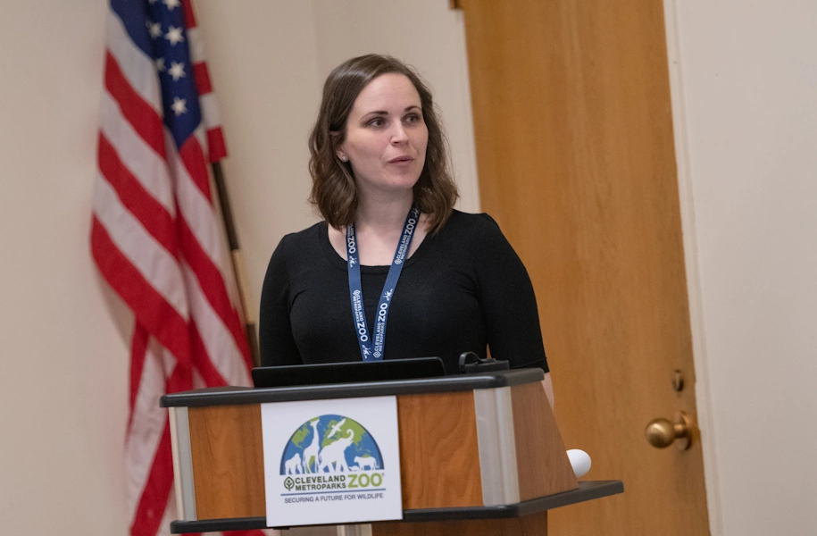 A zoo worker giving a speech behind a podium 