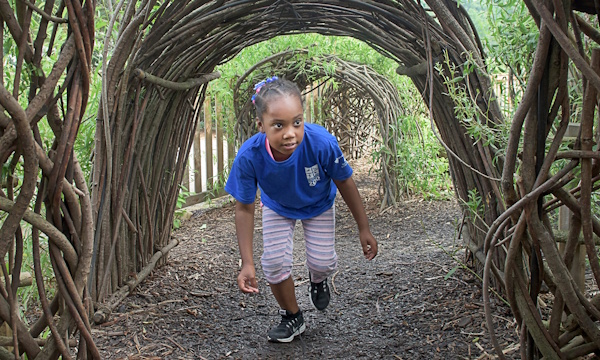 young girl walking through trees