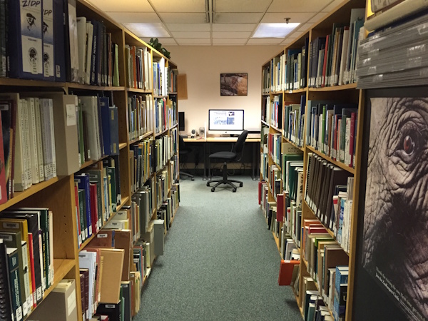 zoo library with bookshelves on either side and a computer in the distance