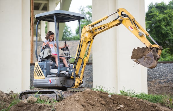 Child exploring large machinery during Touch-a-Truck event