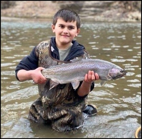 Boy smiling and holding a fish