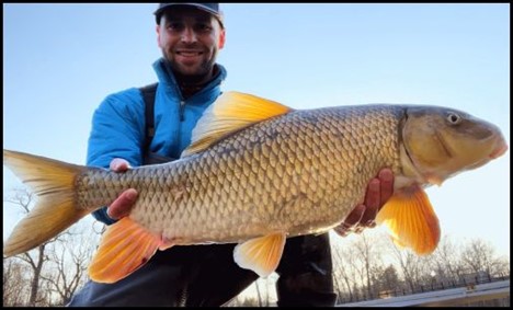 Man smiling and holding a fish