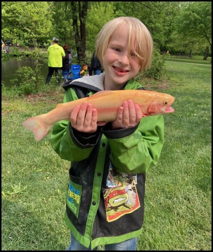 Child smiling and holding a fish