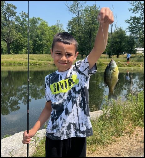 Boy smiling and holding a fish