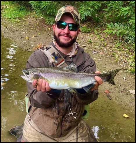 Man smiling and holding a fish