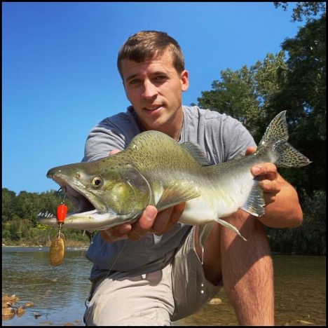 Man smiling and holding a fish