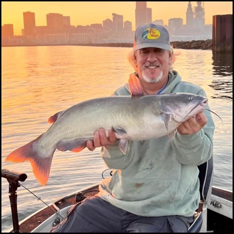 Man smiling and holding a fish