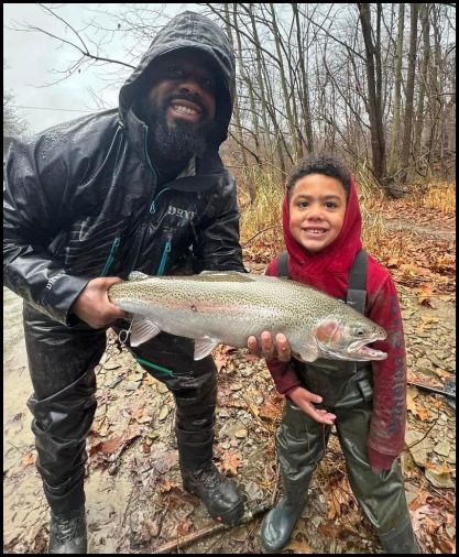 Boy posing with someone holding a fish