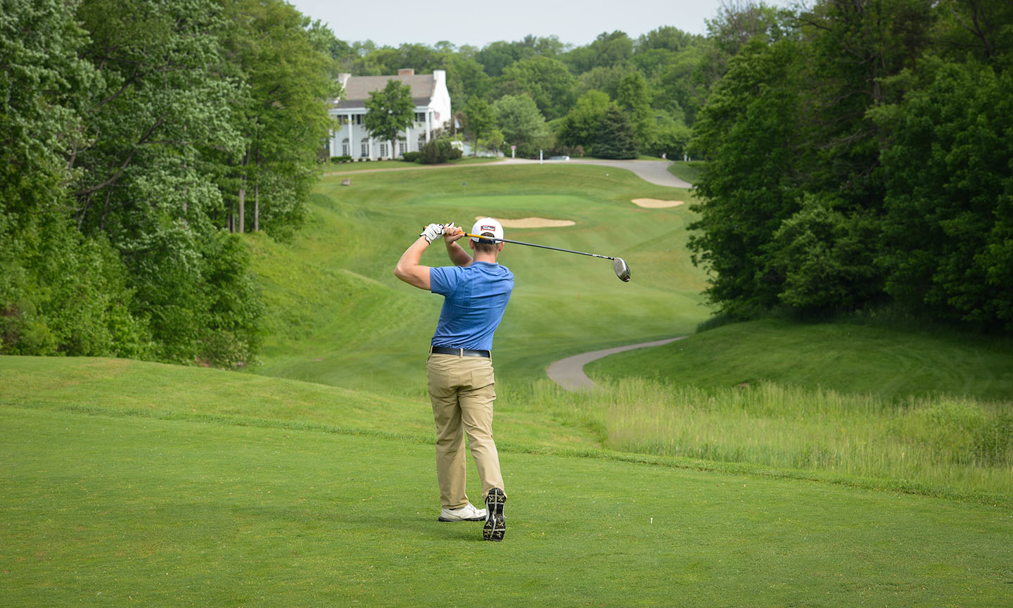 A man swinging a golf club on a golf course