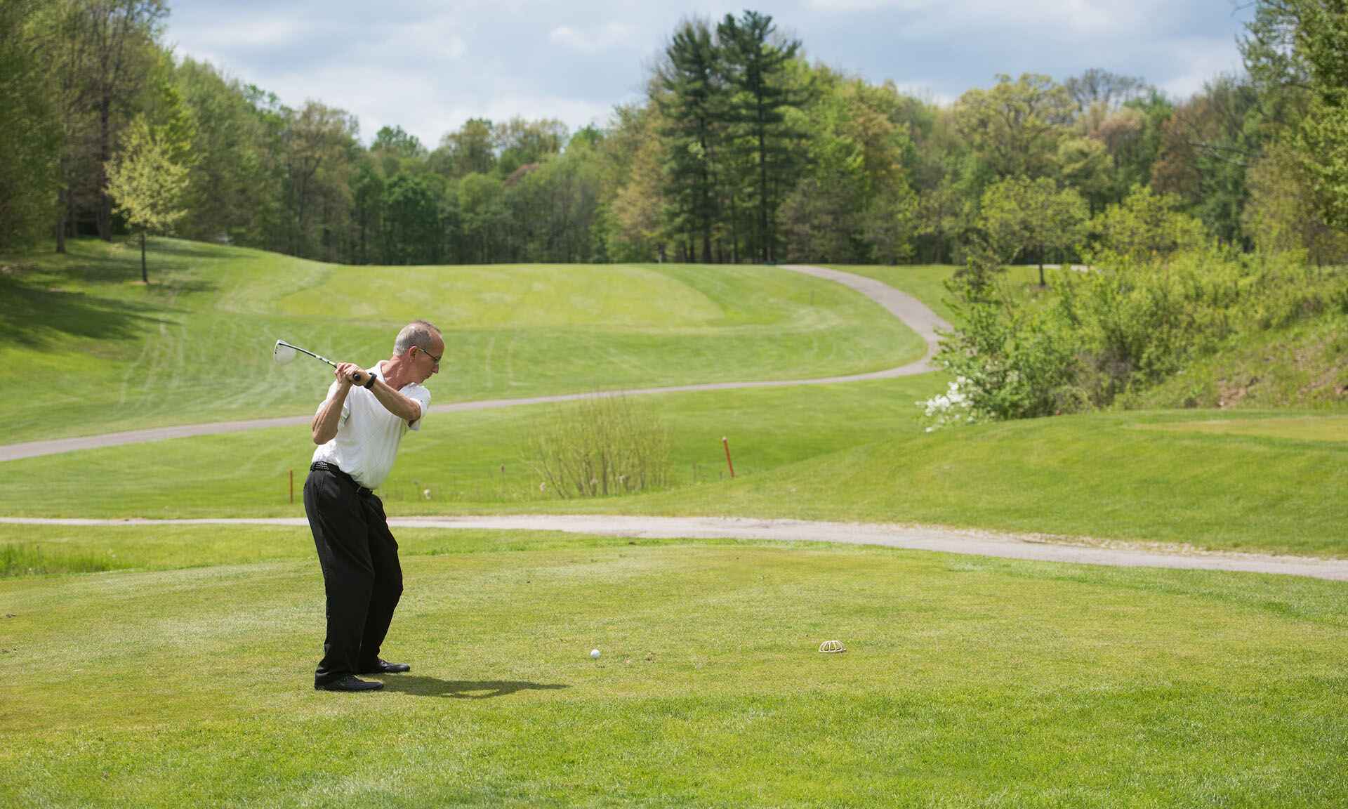 A man swinging a golf club on a golf course