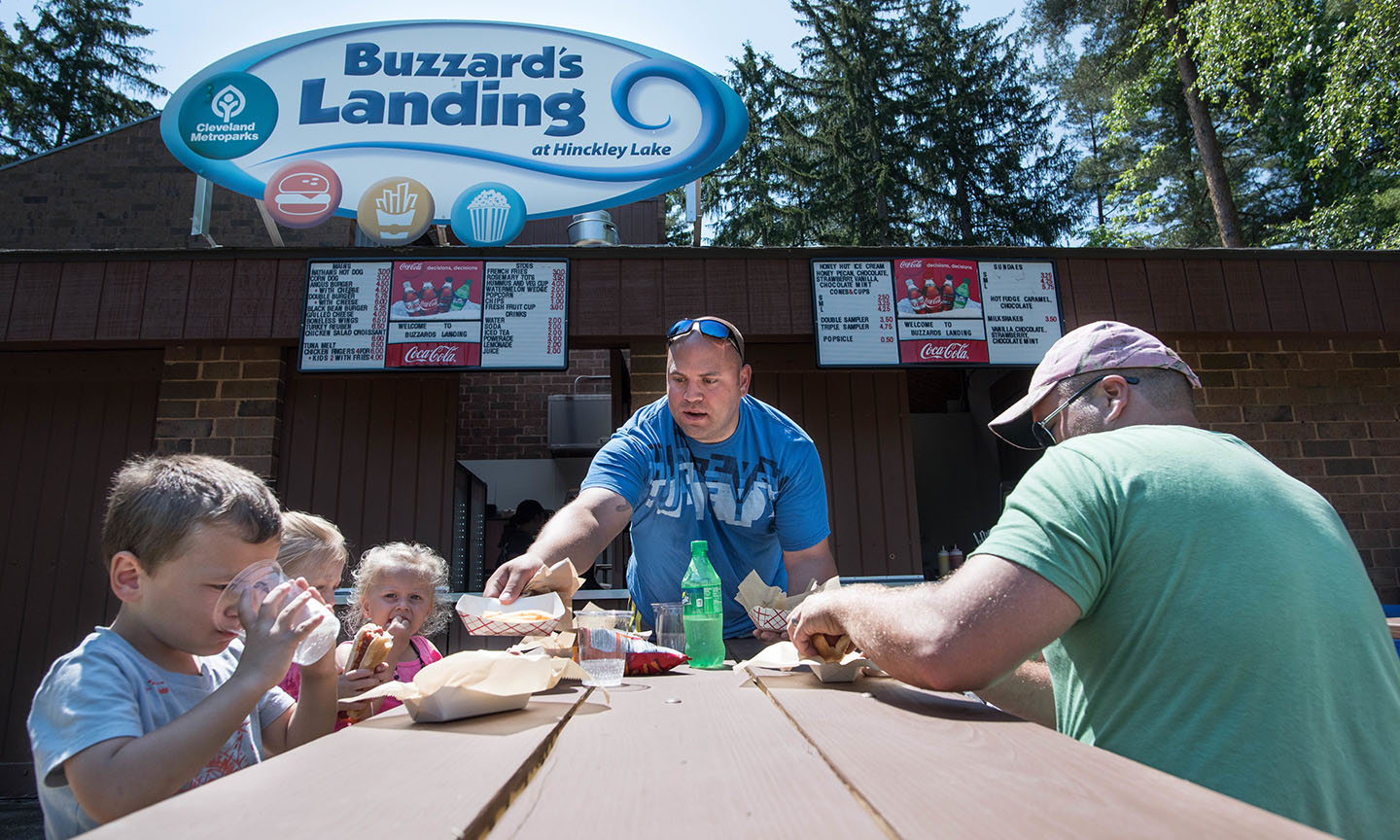 Man handing food to kids at table 