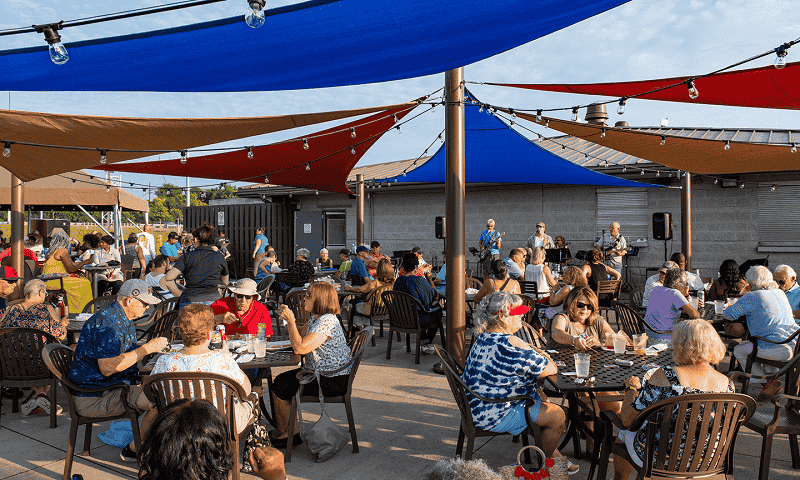 People eating at tables outside of restaurant 