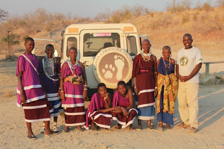 A ground of ruaha carnivore project members in front of a truck