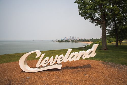  The iconic Cleveland sign is displayed, representing the city with bold letters amidst the urban landscape of Cleveland, Ohio.