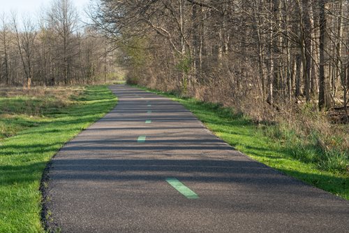 arafed road with a green line on the side of it, a stock photo inspired by David Inshaw, shutterstock contest winner, regionalism, wide greenways, ligjt trail, paved roads