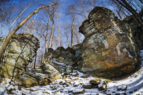 A stone bridge featuring two statues, elegantly positioned on either side, spanning a serene landscape.