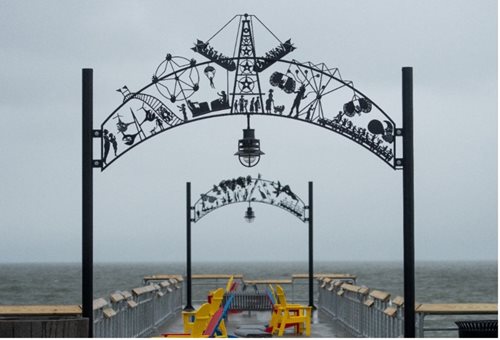 a view of a pier with a metal arch and a sign that says the pier is closed, an art deco sculpture by George Wyllie, shutterstock contest winner, temporary art, metal sculpture, metal art, made of wrought iron