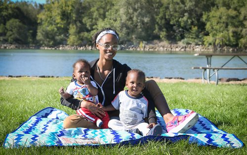 there are two women and two children sitting on a blanket in the grass, a stock photo inspired by Esaias Boursse, trending on cg society, harlem renaissance, humans of new york, humans of new york style, portrait of family of three