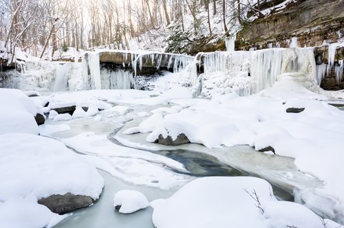 arafed waterfall in the winter with snow and ice covered rocks, a jigsaw puzzle by Jeff Miracola, shutterstock contest winner, regionalism, frozen waterfall, frozen river, beautiful winter area