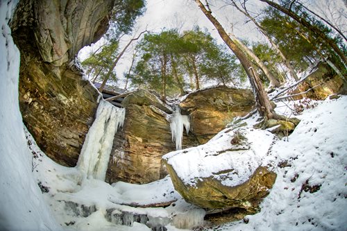 there is a waterfall that is frozen in the middle of a snowy forest, a jigsaw puzzle by Mike Bierek, instagram contest winner, naturalism, frozen waterfall, ice cave, snow cave