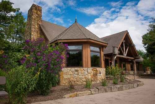 A sturdy stone edifice characterized by a large chimney and a massive stone wall, reflecting classic architectural style.